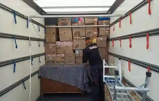 Inside of a 1 Van 1 Man Removals Mercedes Sprinter moving van with secure racking, transit blankets, and stacked packing boxes